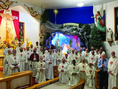 Grupo de Padres Apóstoles del Amor Infinito frente al pesebre de Navidad, Grupa Ojców Apostołów Nieskończonej Miłości przed Szopką Bożonarodzeniową